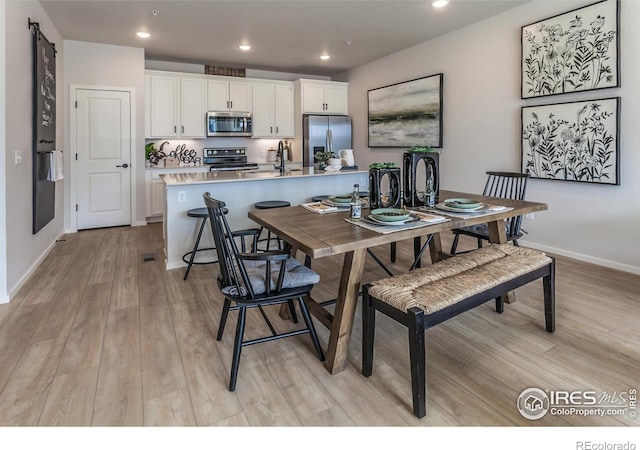 kitchen featuring appliances with stainless steel finishes, light wood-type flooring, white cabinets, and recessed lighting