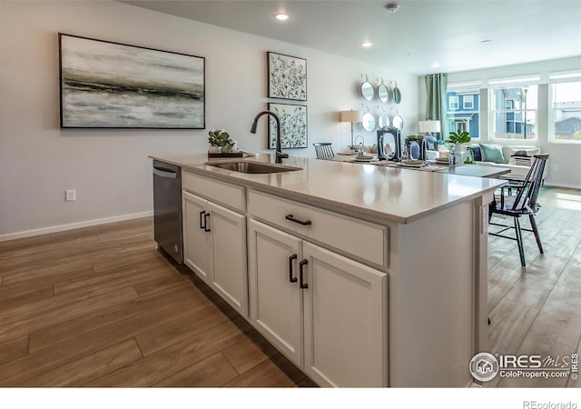 kitchen with dishwasher, light wood-style flooring, white cabinetry, a sink, and recessed lighting