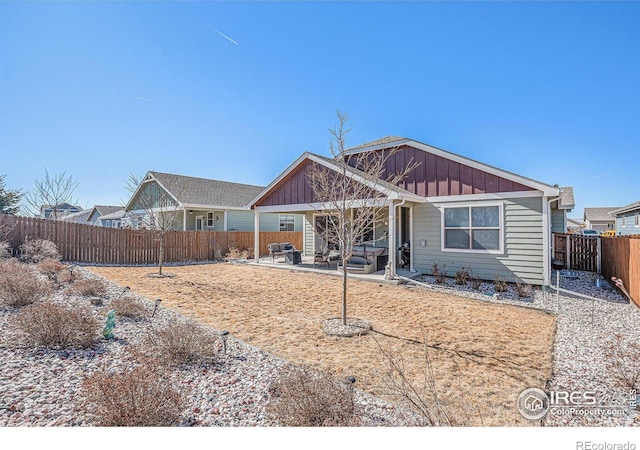 view of front of home with a fenced backyard, board and batten siding, and a patio