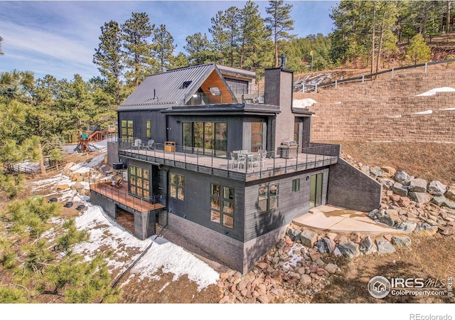 back of property featuring a chimney and a balcony