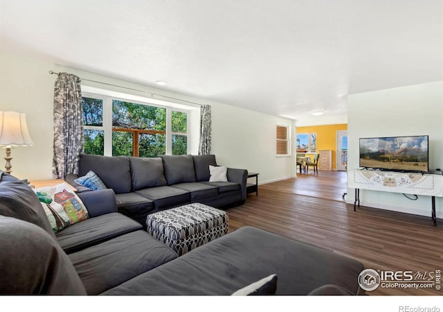 living area featuring dark wood-style floors and baseboards