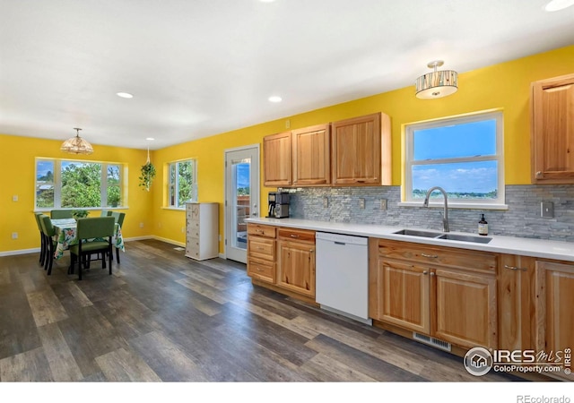 kitchen featuring dark wood-style flooring, a sink, light countertops, hanging light fixtures, and dishwasher