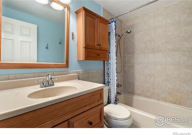 bathroom with toilet, shower / tub combo with curtain, and vanity