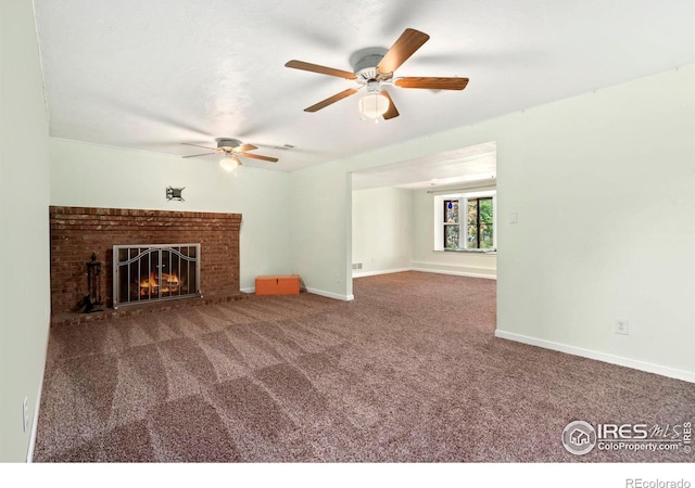 unfurnished living room featuring a ceiling fan, carpet, a brick fireplace, and baseboards