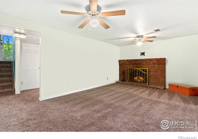 unfurnished living room featuring stairs, carpet floors, a fireplace, and visible vents