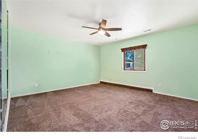 unfurnished room with carpet, visible vents, ceiling fan, and baseboards