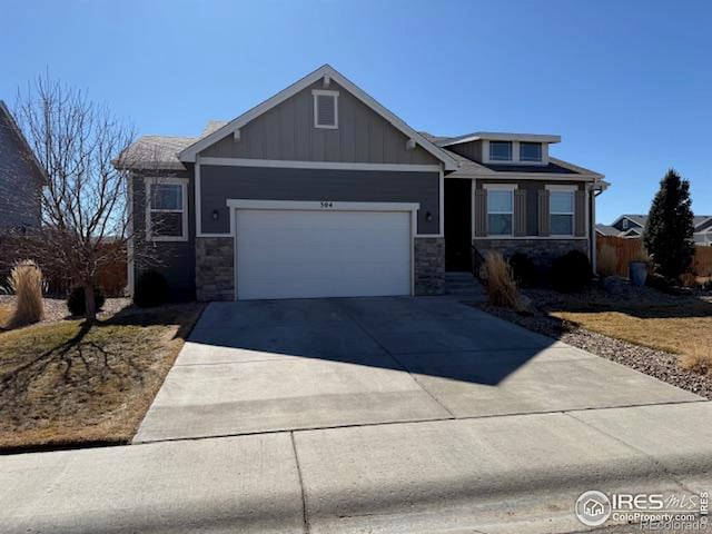 craftsman inspired home with a garage, stone siding, board and batten siding, and concrete driveway