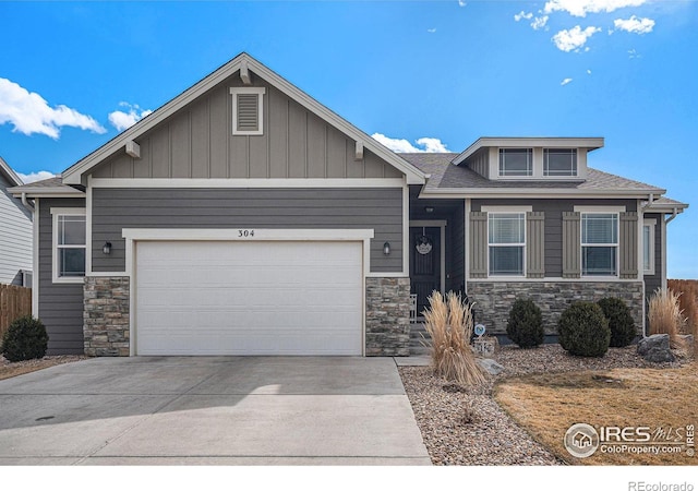 craftsman-style home with a garage, stone siding, and concrete driveway