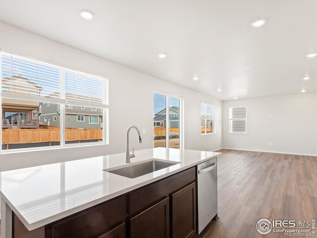 kitchen featuring light wood finished floors, recessed lighting, a sink, dark brown cabinets, and dishwasher