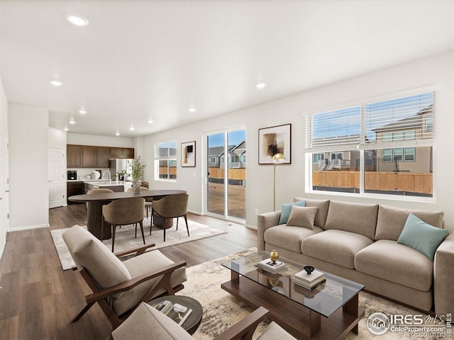 living area with recessed lighting, baseboards, and wood finished floors