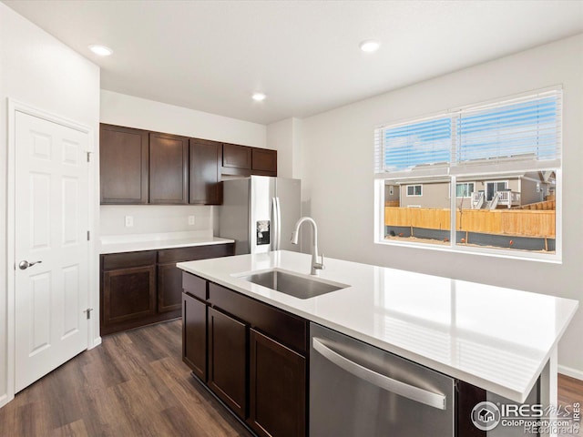 kitchen with dark brown cabinetry, stainless steel appliances, a sink, and light countertops