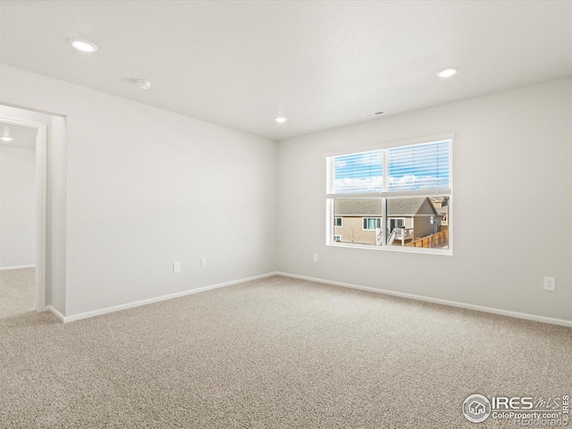 carpeted empty room featuring baseboards and recessed lighting