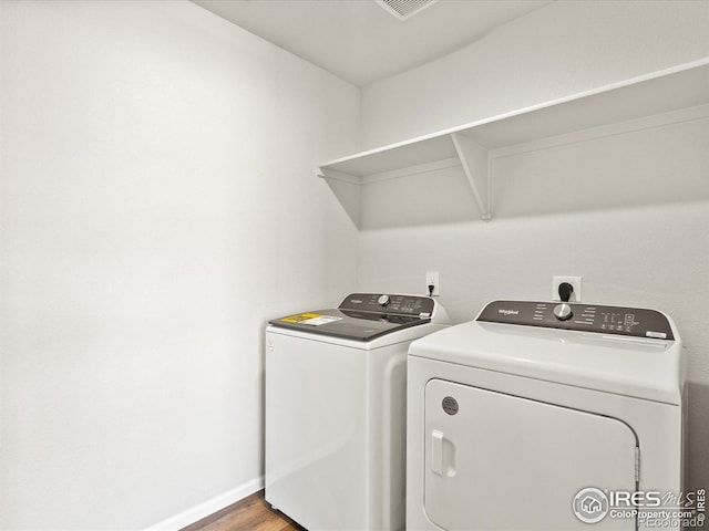 laundry area with laundry area, baseboards, wood finished floors, and independent washer and dryer