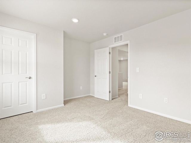 unfurnished bedroom with carpet floors, visible vents, and baseboards