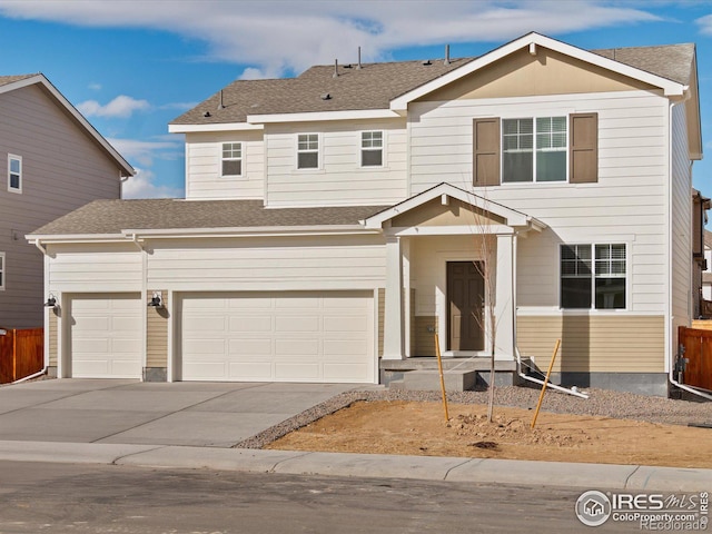 traditional home with concrete driveway, roof with shingles, an attached garage, and fence