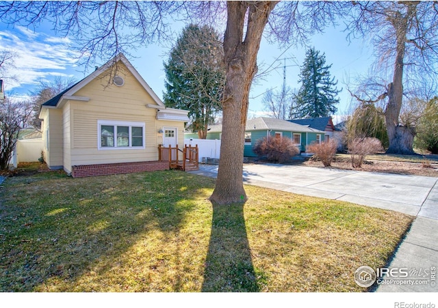 view of front of home featuring driveway, a front yard, and fence