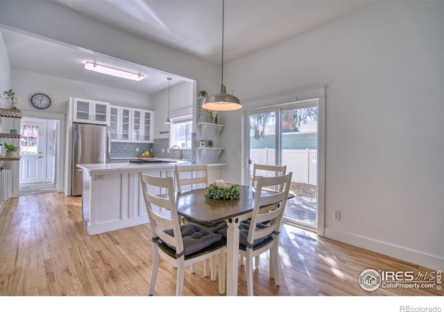 dining area featuring light wood-style flooring and baseboards