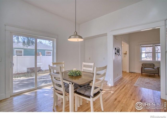 dining space featuring baseboards and light wood finished floors