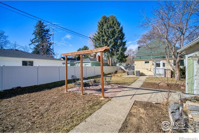 view of yard featuring a patio, an outdoor structure, and fence