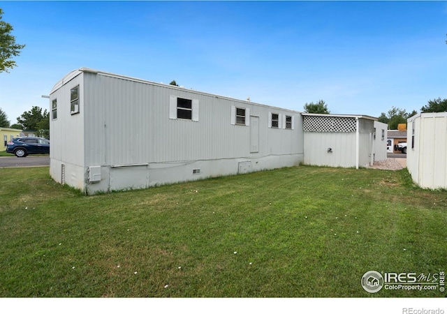 back of house with crawl space and a yard