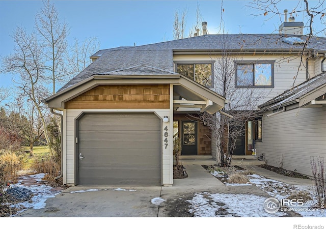 view of front of house featuring a shingled roof, driveway, and an attached garage