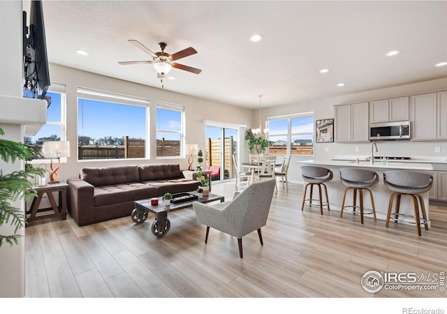 living room with recessed lighting, a ceiling fan, and light wood-style floors