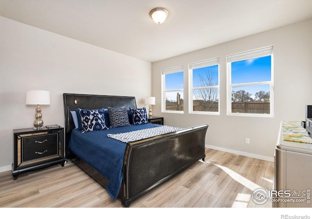 bedroom featuring baseboards and light wood finished floors