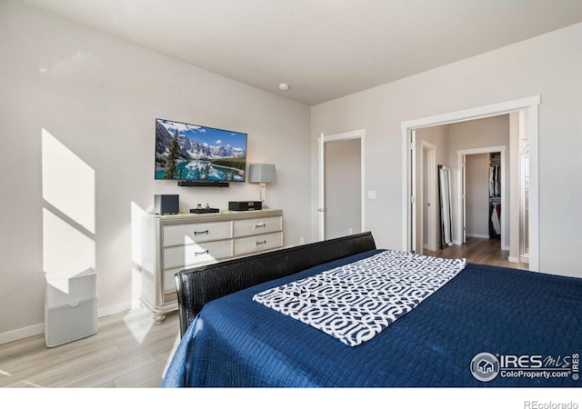 bedroom featuring light wood-style flooring and baseboards