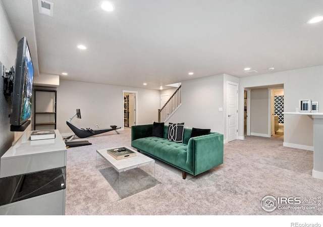 living area featuring carpet floors, recessed lighting, visible vents, stairway, and baseboards