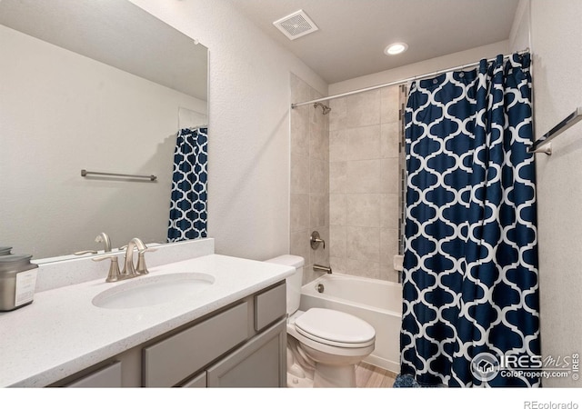 full bath featuring a textured wall, toilet, vanity, visible vents, and shower / bath combo with shower curtain