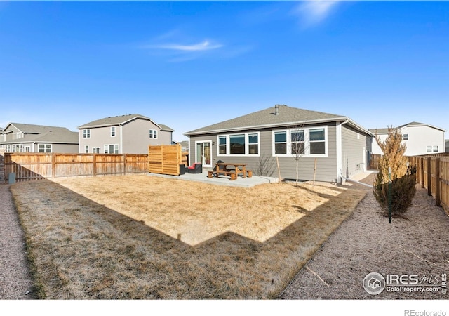 rear view of property with a fenced backyard, a residential view, and a patio