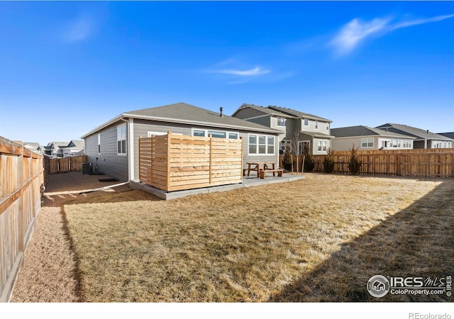 back of property featuring a patio area, a fenced backyard, a residential view, and a yard