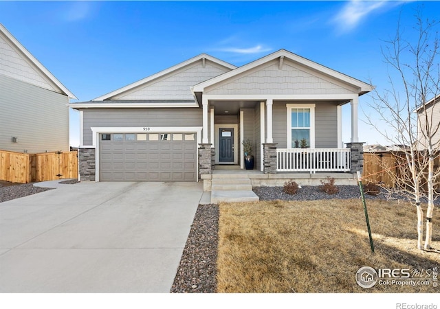 craftsman house featuring a porch, an attached garage, fence, driveway, and stone siding