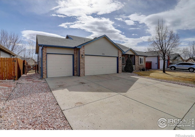 ranch-style house featuring concrete driveway, a residential view, an attached garage, fence, and brick siding