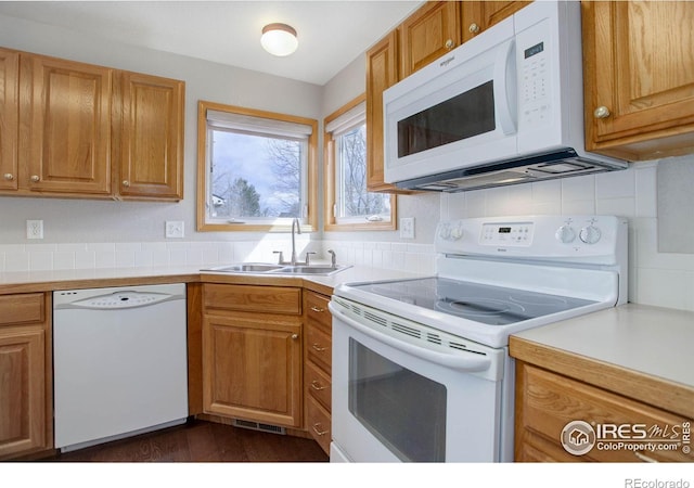 kitchen with tasteful backsplash, light countertops, visible vents, a sink, and white appliances