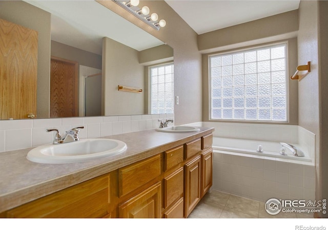 full bath featuring tile patterned flooring, a garden tub, a sink, and double vanity