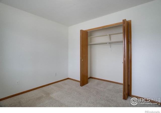 unfurnished bedroom featuring carpet floors, a closet, and baseboards