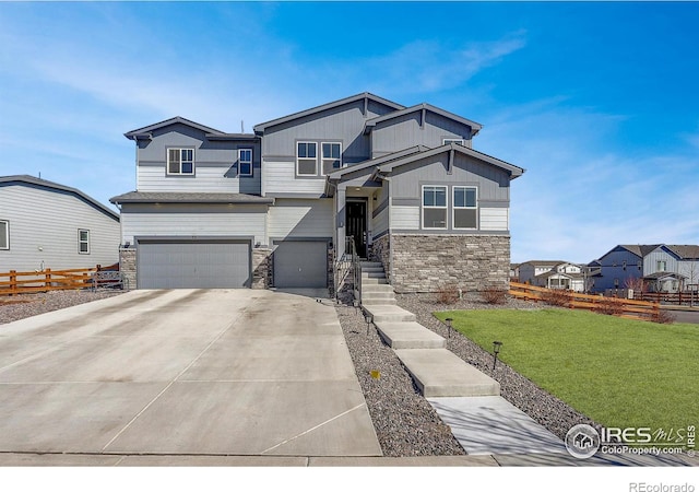 craftsman-style home featuring a garage, concrete driveway, stone siding, fence, and a front lawn