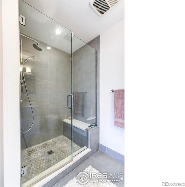 bathroom with tile patterned floors, baseboards, a stall shower, and visible vents