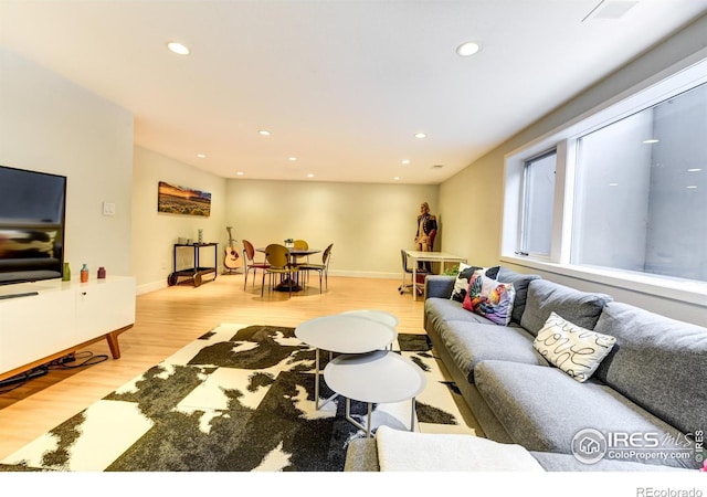 living room featuring recessed lighting, light wood-type flooring, and baseboards