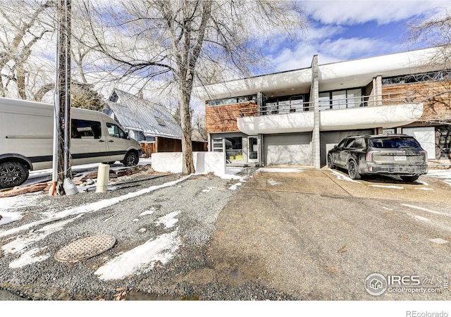 view of front of property featuring a garage, a balcony, and driveway