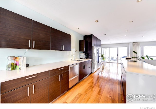 kitchen featuring a sink, modern cabinets, light wood-style flooring, and light countertops