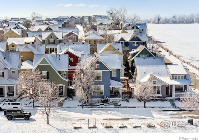 snowy aerial view with a residential view