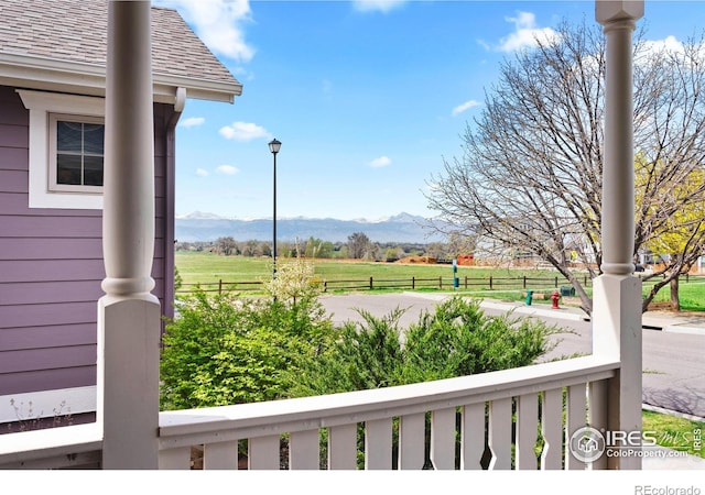 view of yard with a rural view, a mountain view, and fence