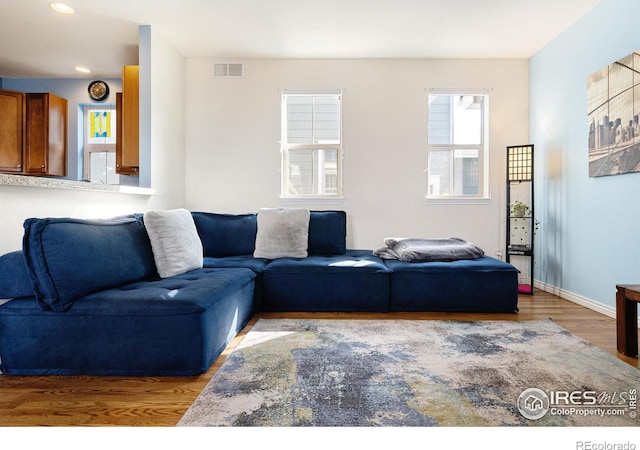 living room featuring recessed lighting, visible vents, baseboards, and wood finished floors