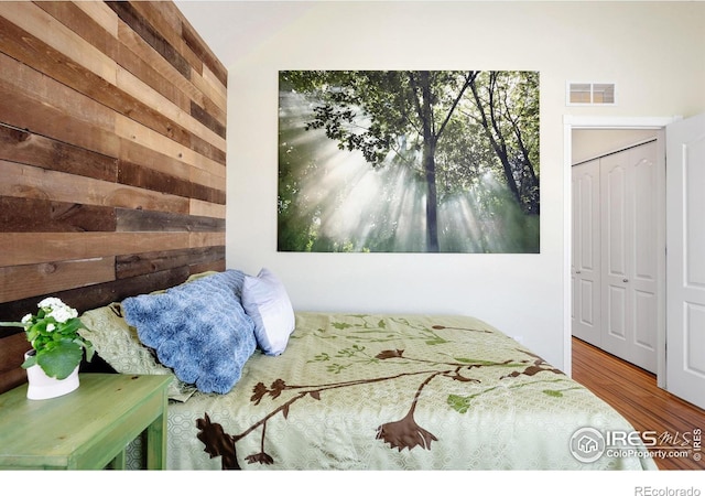 bedroom featuring wood finished floors and visible vents