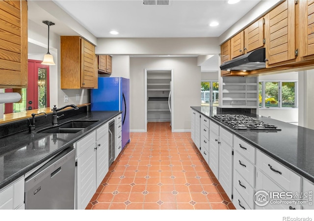 kitchen with light tile patterned floors, under cabinet range hood, stainless steel appliances, a sink, and white cabinetry