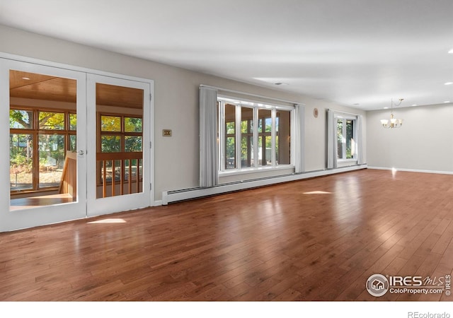 unfurnished living room with a baseboard radiator, an inviting chandelier, wood-type flooring, and french doors