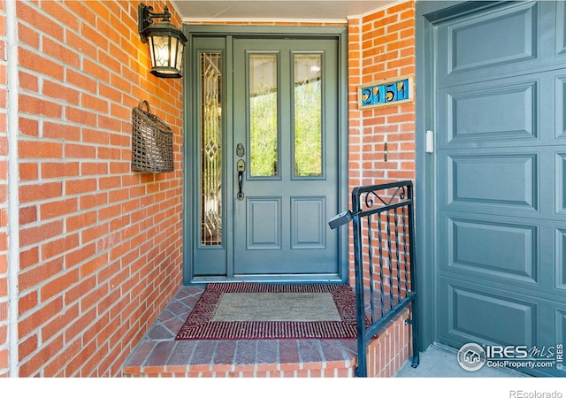 doorway to property featuring brick siding and a porch