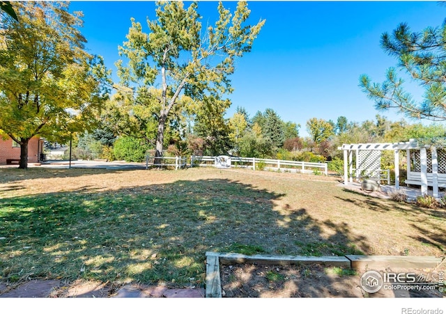 view of yard with fence and a pergola